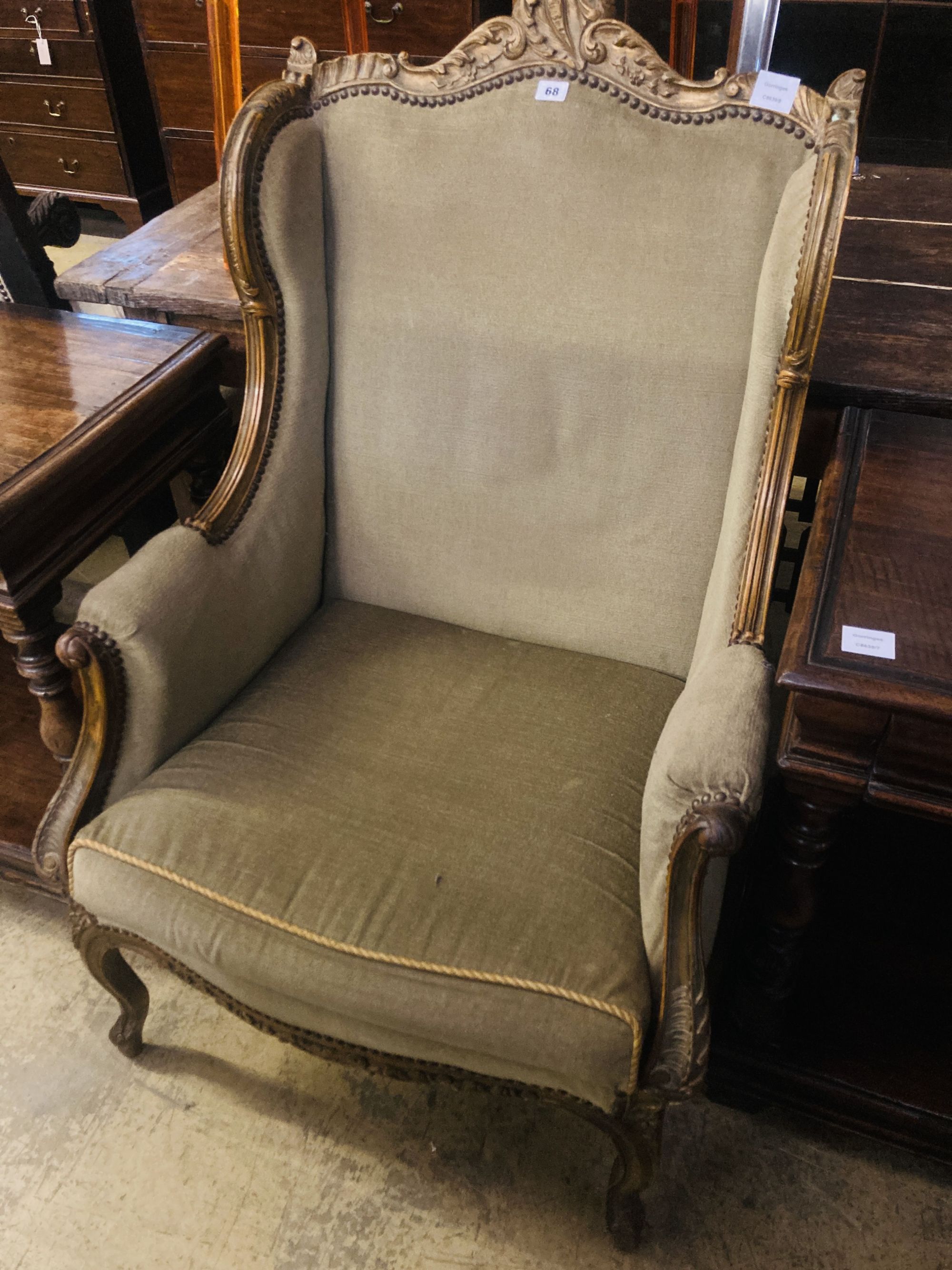 An early 20th century French parcel gilt carved beech wing armchair, width 70cm, depth 66cm, height 115cm